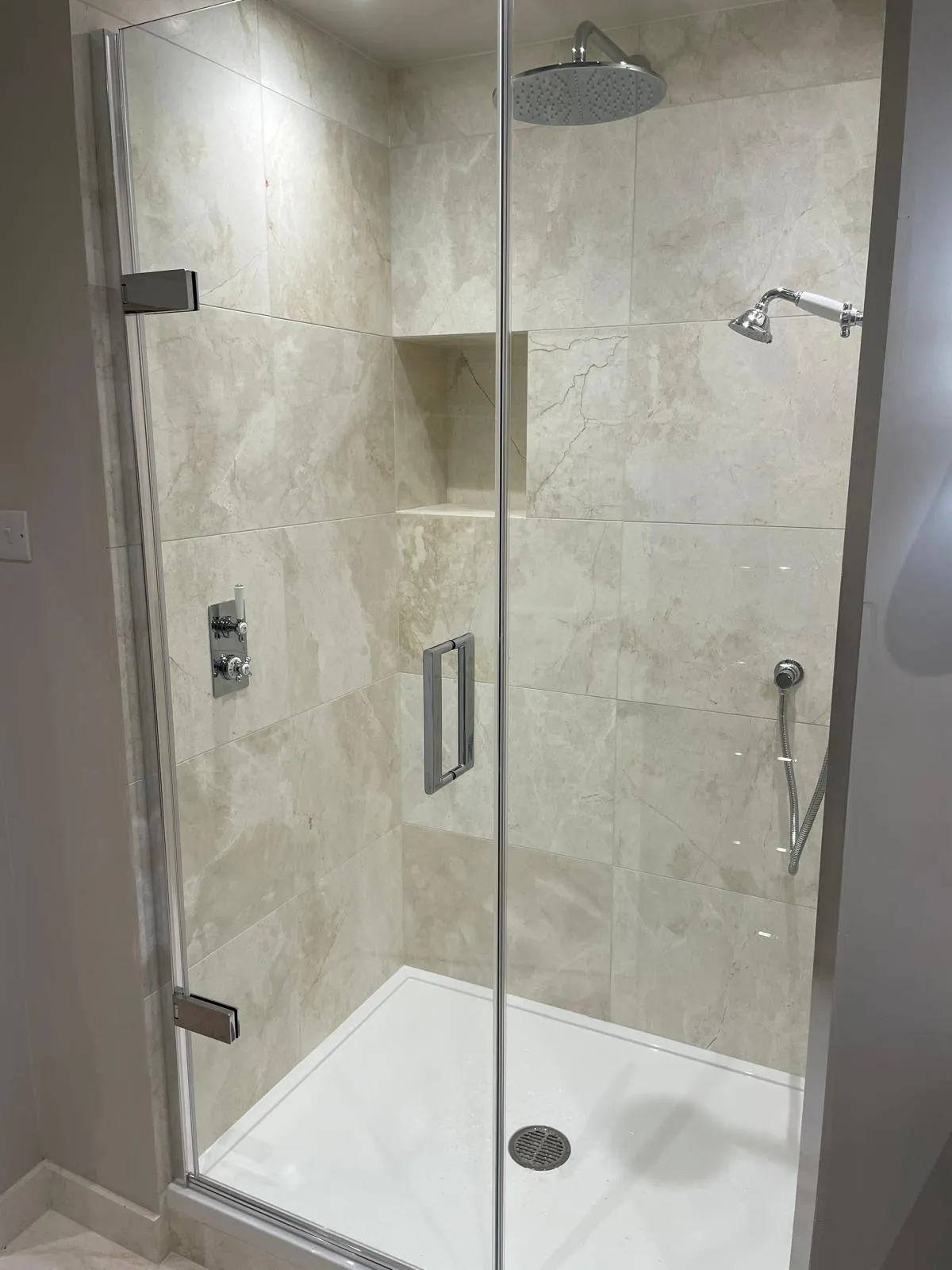Shower finished in cream marble tiles