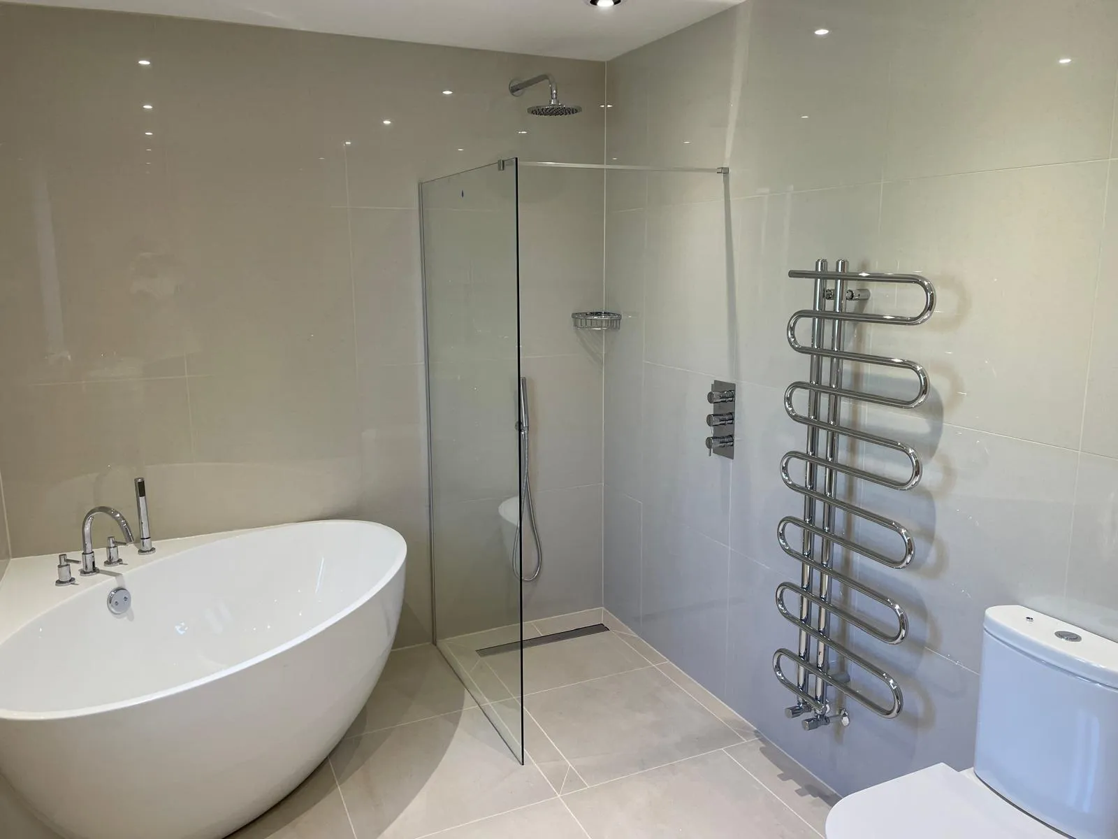 Bathroom with a freestanding bath, a walk-in shower and a chrome ladder radiator