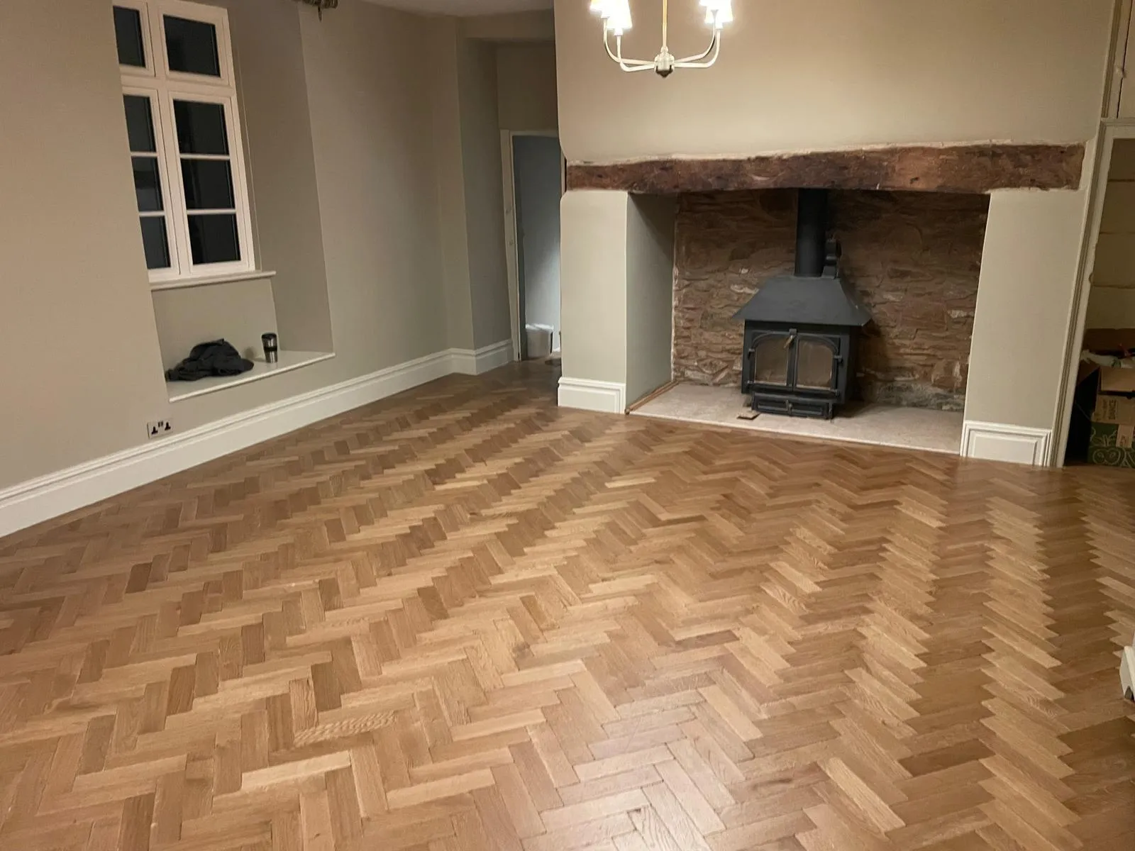 Herringbone oak floor in a living room with a stove